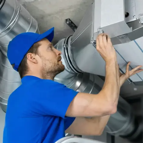 Technician installing ventilation and air duct system