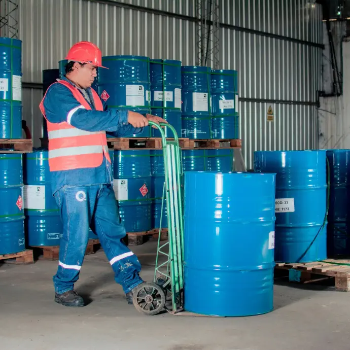 Technician managing spill containment drums for petroleum safety compliance
