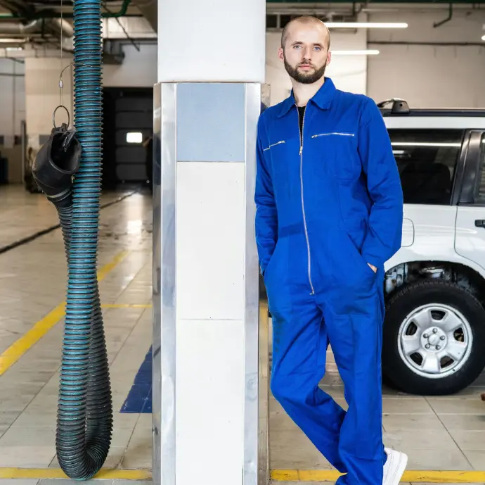 Worker wearing full blue coverall uniform for petroleum field operations
